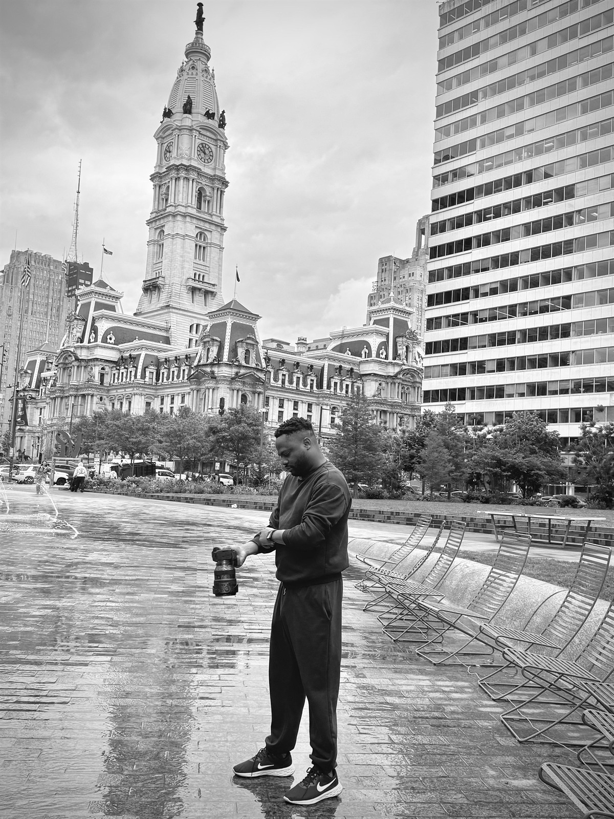 The photographer behind Cabrini Studios adjusting his camera in front of Philadelphia City Hall