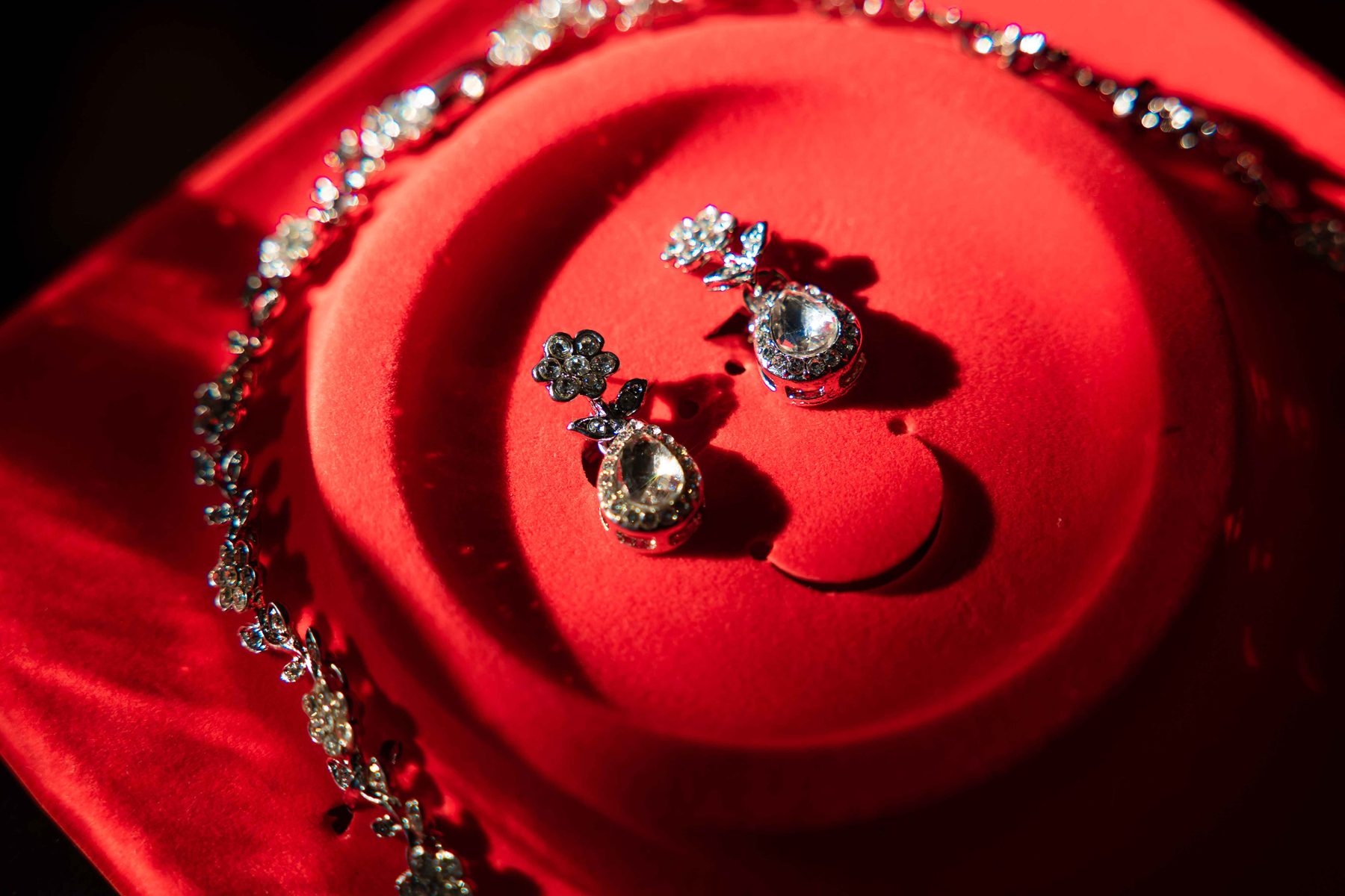 Statement earrings and jewelry styled on red velvet