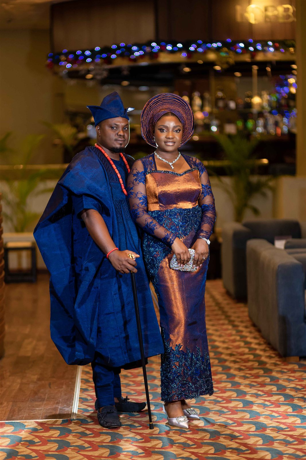 Bride and groom in matching navy and gold traditional aso-oke attire